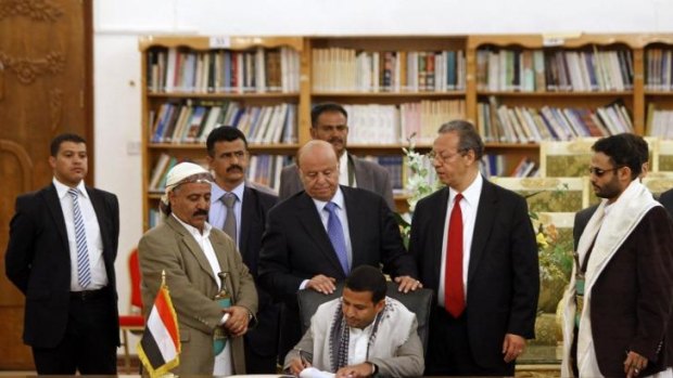 Peace deal: The head of political relations for the Houthi movement, Hussein al-Ezzi, signs an agreement, flanked by President Abd-Rabbu Mansour Hadi (blue tie) and UN special envoy Jamal Benomar in Sanaa.