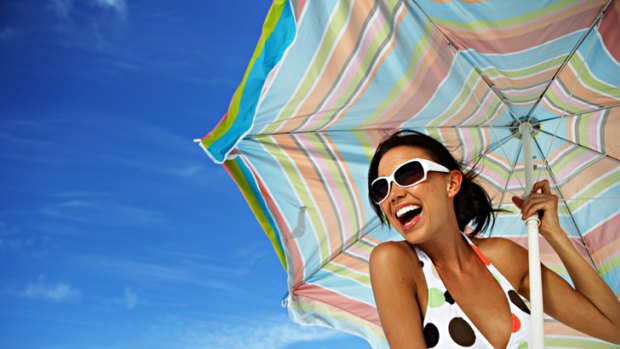Generic pic of a woman wearing a bikini on the beach, umbrella, swimming, summer.