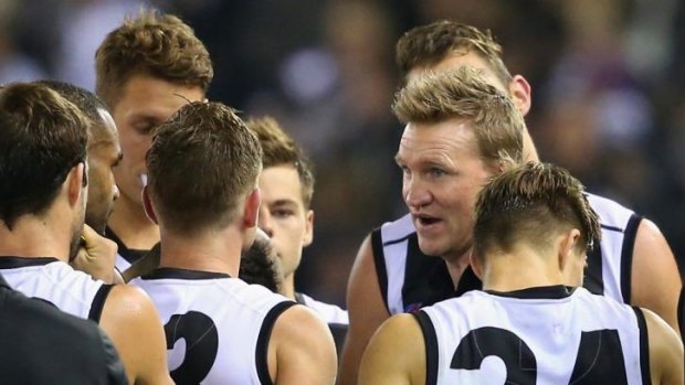 Nathan Buckley has a quiet word with his players during a break.