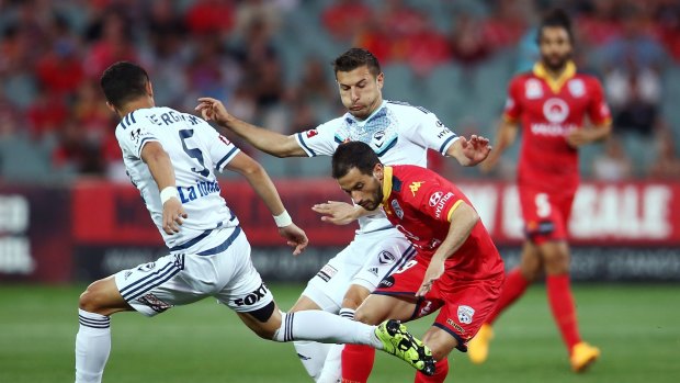 Sergio Cirio of Adelaide United attempts to get past two Victory defenders during Friday's match.