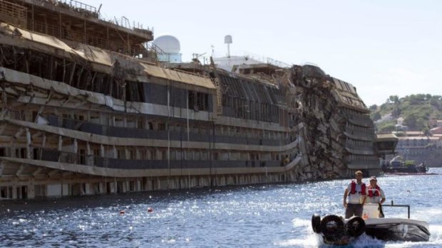 A small boat passes next to the damaged side of the Costa Concordia on the Tuscan Island of Giglio, Italy in September.