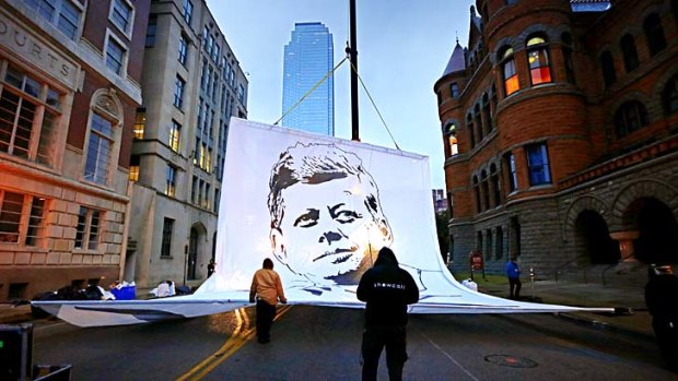 Anniversary: Workers raise a banner in Dealey Plaza, Dallas.