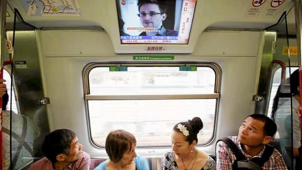 Passengers watch news on Edward Snowden on a train in Hong Kong.