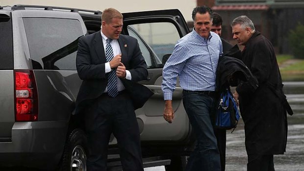 Secret Service agents look on as Republican presidential candidate Mitt Romney boards his campaign plane. In the wake of Hurricane Sandy, the campaign has reduced their schedule and is focusing on disaster relief.
