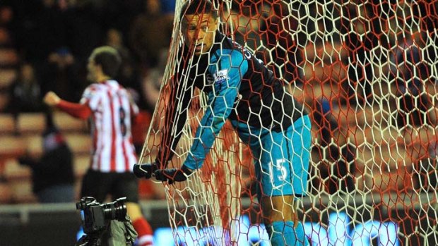 Down and out: Arsenal's Alex Oxlade-Chamberlain after his own goal helped Sunderland to victory.