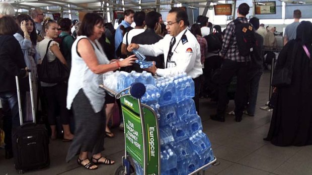 Passengers are handed water at Sydney Airport after lengthy delays.
