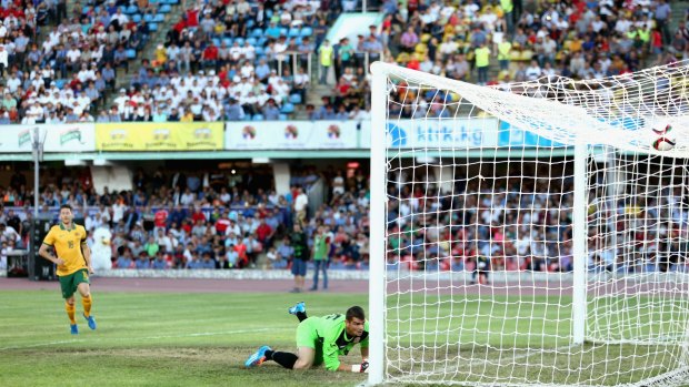 Bad bounce ... Kyrgyzstan goalie Valerii Kashuba fails to stop a free kick by Australian captain Mile Jedinak.