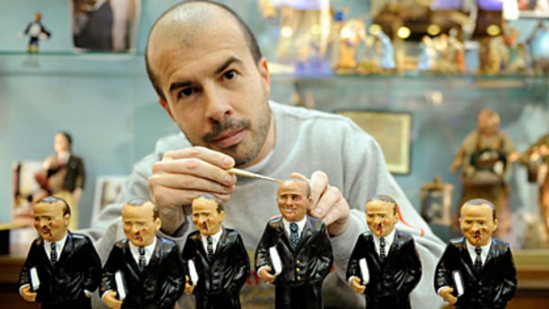 Italian handcraftman Marco Ferrigno works on Silvio Berlusconi figurines at a Napolitan craftsmen shop on December 15, 2009.