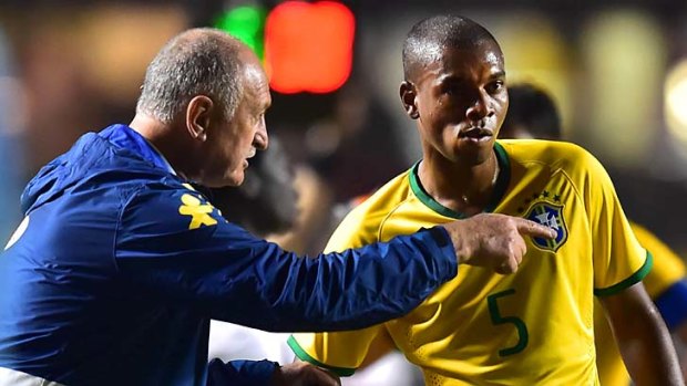 Brazil coach Luiz Felipe Scolari gives instructions to Fernandinho during the match against Serbia.