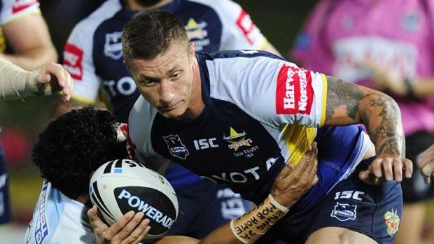 Shark attack ... Tariq Sims of the Cowboys is tackled by Albert Kelly.