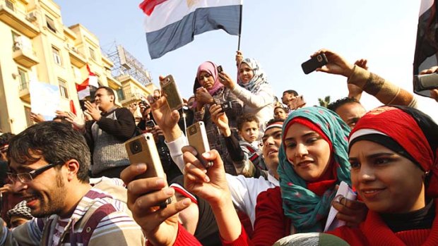 Tweeting the revolution ... Egyptians use their mobile phone to record celebrations in Cairo's Tahrir Square during last year's Arab Spring uprising.