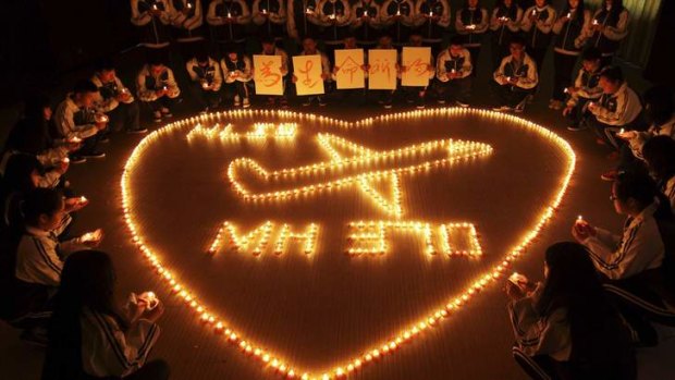 Heartbreak: International school students light candles  for passengers aboard Malaysia Airlines flight MH370, in Zhuji, Zhejiang province. The placards held by children read "Pray for life".