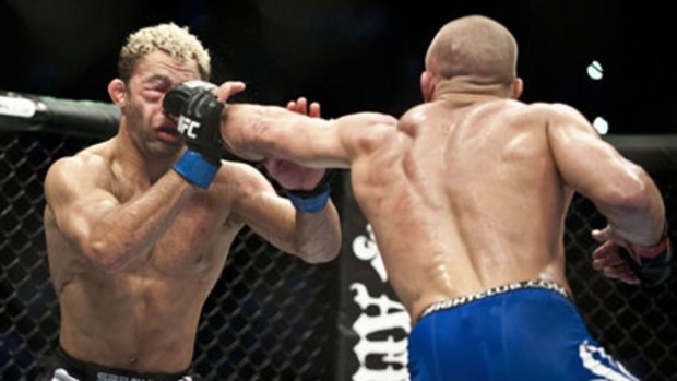 Josh Koscheck (left) sustains yet another Georges St-Pierre blow to his badly damaged right eye during their UFC welterweight title bout in Montreal. St-Pierre won the bout and retained his title.