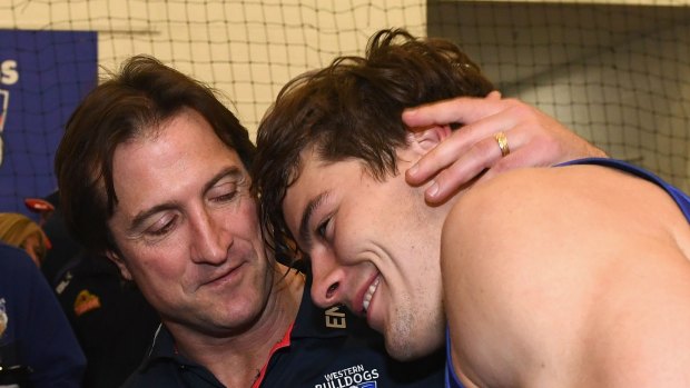 Luke Beverage congratulates Josh Dunkley after the Bulldogs beat the Hawks on Friday night.