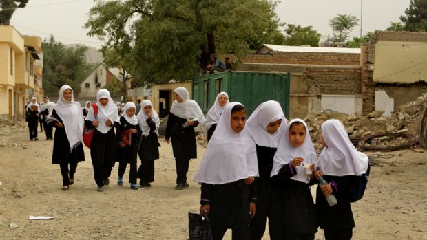 School of hard knocks: Afghan girls walk home after class through the streets of Kabul. The number of girls attending school drops dramatically after primary level.