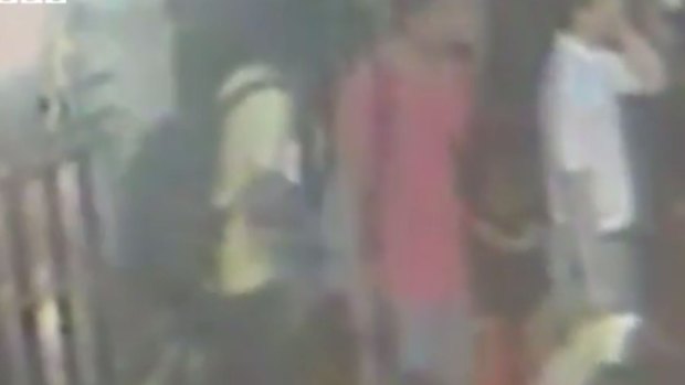 Screen grab of CCTV footage shortly before the Bangkok bomb blast shows a man in a yellow T-shirt with a backpack thought to carry the bomb. The men in the red and white shirts are no longer suspects.
