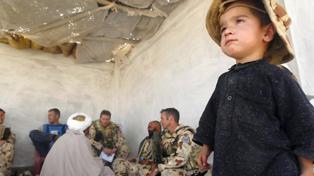 The ADF caption on this picture said: "An Afghan boy displays his loyalty to Australian engineers meeting with the village elder."