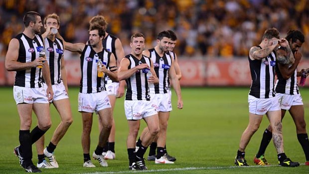 Poor defence: Dejected Collingwood players leave the ground after leaking 20 goals to Hawthorn.