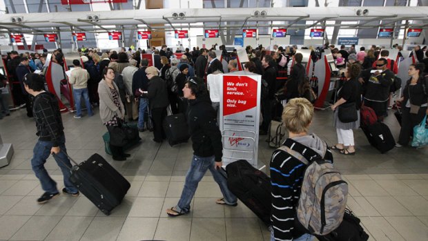 Passengers queue at the Virgin terminal in Sydney earlier today.