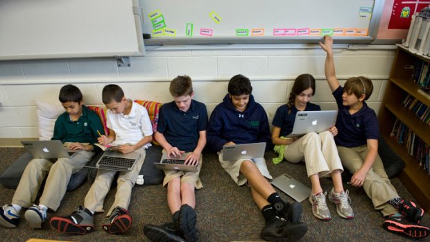 Children at Flint Hill School  work on their school-issue laptops.