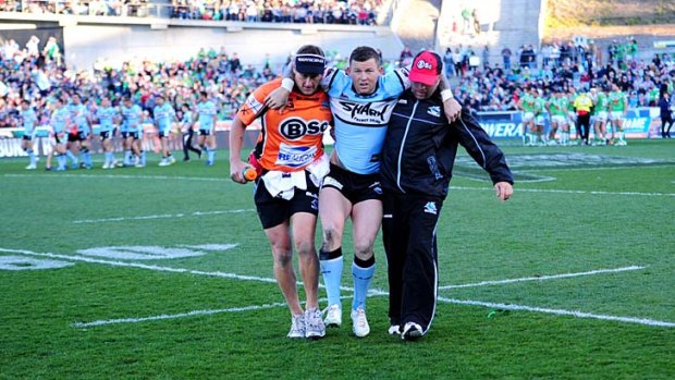 The Sharks Todd Carney leaves the field with an injury.