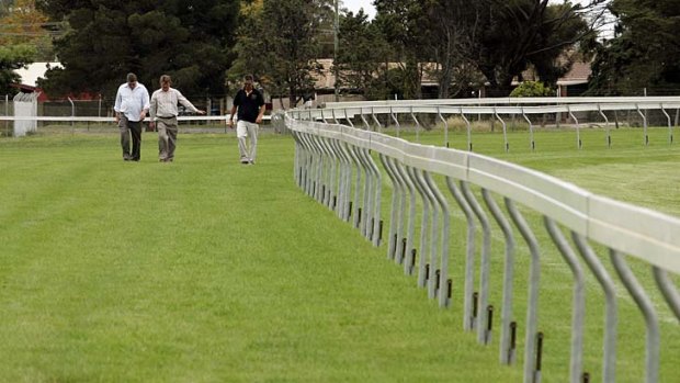 Officials inspect the condition of the Werribee Racecourse track.