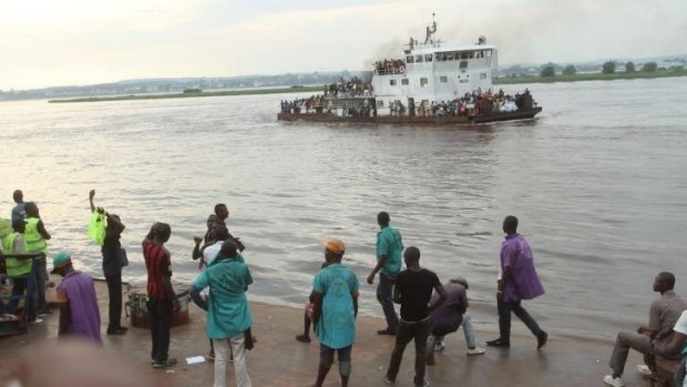 People that have been deported from Congo's capital Brazzaville, seen in background, arrive by river boat in Kinshasa, Democratic Republic of Congo.