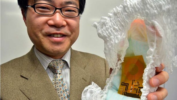 University of Tokyo professor Takao Somey holds a nappy containing the world's first flexible wireless organic sensor system.