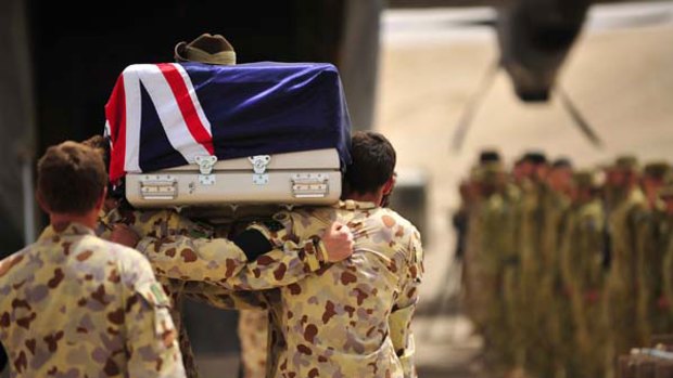 Lance Corporal Jared MacKinney is farewelled by soldiers from the First Mentoring Task Force during a ceremony at the Tarin Kowt base, Afghanistan. <i>Picture: LS Paul Berry/ADF</i>