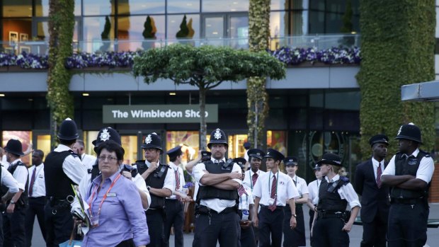 Police evacuate the area after a fire broke out inside Centre Court at the end of play.