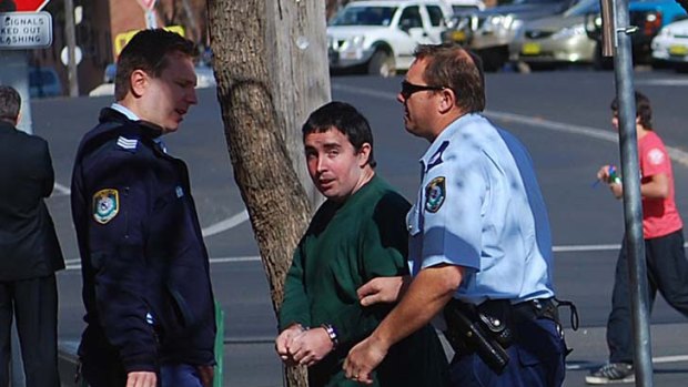 Police leading alleged hacker David Cecil into Cowra Local Court today.