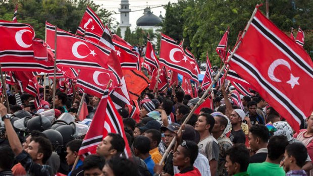 Provocative: Acehnese demonstrators wave banned separatist flags during a protest in Banda Aceh.