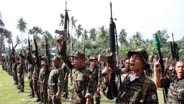 Members of the Moro Islamic Liberation Front rebels raising their rifles during a ceremony in 2012.