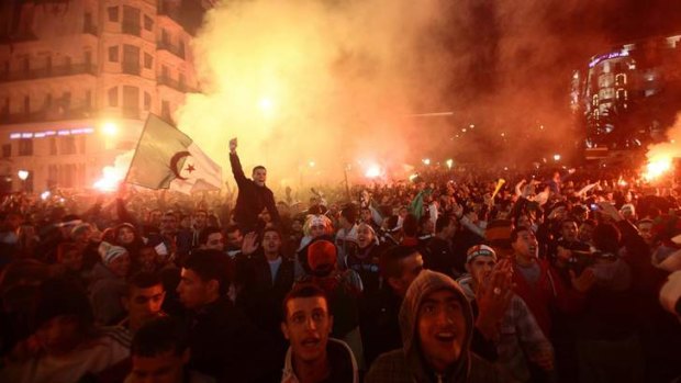 Tragedy after joy ... Algerian football fans hold the country's national flag as they celebrate in downtown Algiers, after their team defeated Burkina Faso to qualify for the 2014 World Cup.