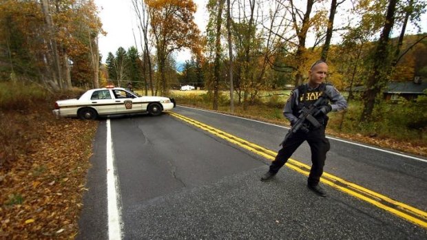 A Pennsylvania State Trooper patrols along a closed section of Lower Swiftwater Road during a massive manhunt for killer Eric Frein in Swiftwater, Pennsylvania.