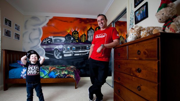 Commercial graffiti artist Ashley Goudie (right) in front of the GT Ford Falcon he spray painted in the bedroom of Braxton Vella, 3, (left) of Melton.