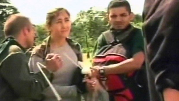 In this frame grab from a video released by Colombia's Army, hostage Ingrid Betancourt is seen with her hands tied together as she stands with unidentified hostages during a Colombian military mission that rescued them.