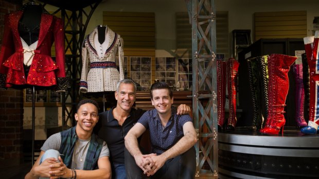 Director Jerry Mitchell, centre, with actors Callum Francis, left, and Toby Francis – and some of the sparkling costumes from <i>Kinky Boots</i>.