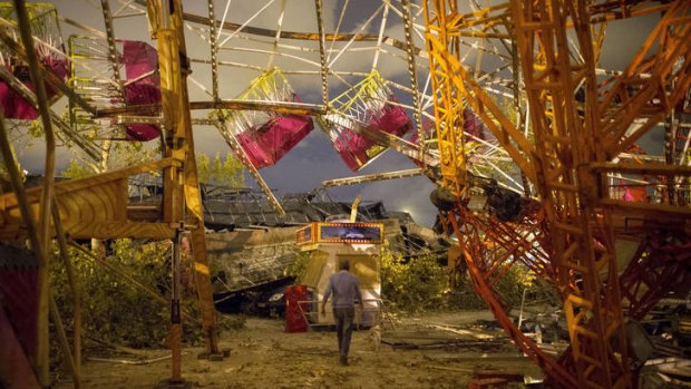 A man walks under the wreckage of a ride at the fair in Gandia, near Valencia.