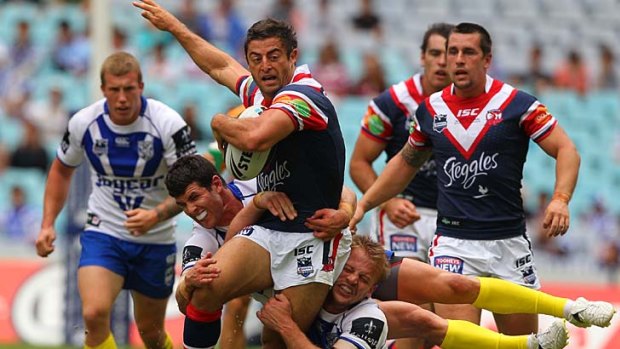 Roosters Anthony Minichiello is tackled by Michael Ennis and David Stagg.