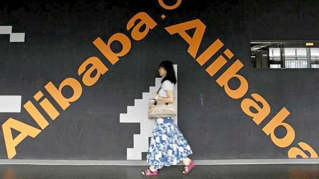 An employee walks past a wall painted with the logo of Alibaba at its headquarters on the outskirts of Hangzhou, China.