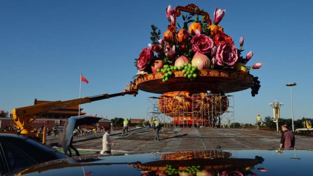 Workers install the giant vase containing fruit and flowers as part of the upcoming Chinese National Day celebrations at Tiananmen Square in Beijing.