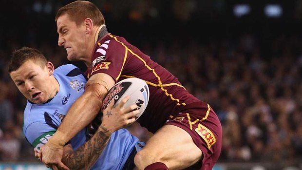 Wrapped up &#8230; Origin rookie Todd Carney is taken down by veteran Brent Tate.