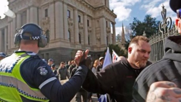 A Victoria Police officer appears to high-five a protester.