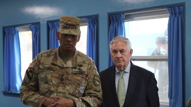 Rex Tillerson is briefed by US General Vincent Brooks while being watched by a North Korean soldier at the border village of Panmunjom.