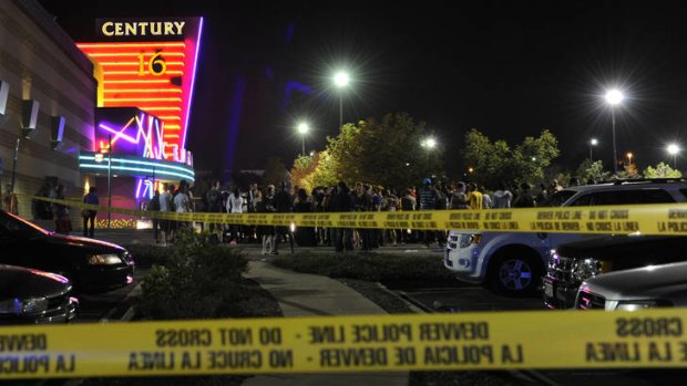 People gather outside a suburban Denver cinema complex where a gunman opened fire just after a midnight movie had begun.