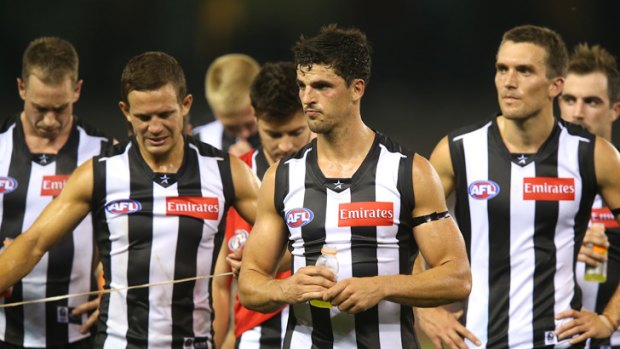 Crushed: Collingwood players leave the ground after their 70-point  loss.