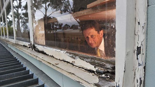 Essendon Keilor College principal David Adamson inspects damaged woodwork at the college's Niddrie campus yesterday.