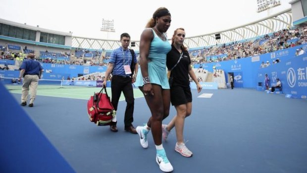 Serene Williams is helped off the court in Wuhan after she took ill during the first set of her match against Alize Cornet.
