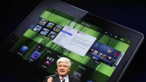 Mike Lazaridis, president and co-chief executive officer of Research in Motion, holds the new Blackberry PlayBook with a screen projection of the device as he speaks at the RIM Blackberry developers conference in San Francisco, California.